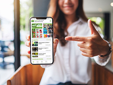 Een vrouw die een mobiele telefoon met de app laat zien.